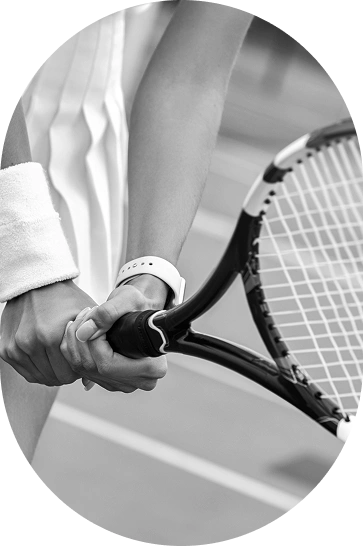 A close-up of a tennis player holding a racket on the court, representing tennis training, match preparation, player performance, and competitive tournaments.