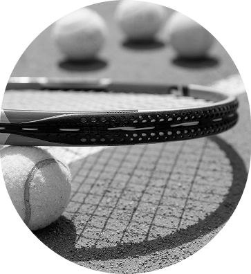 A tennis racket resting beside tennis balls on the court, symbolizing tennis competitions, tournament coverage, player rankings, and sports analysis.